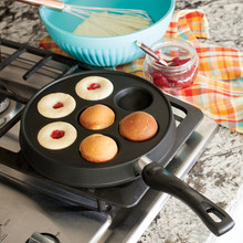 Nordic Ware cast iron Danish ebelskiver pan with seven round wells, black finish, shown from above