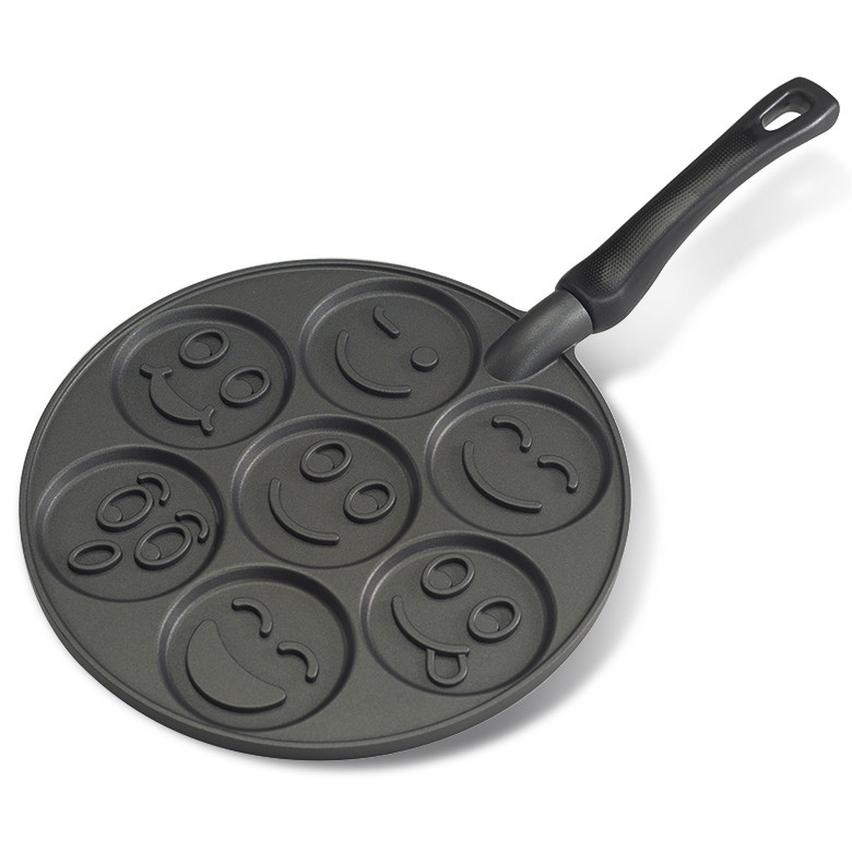 Nordic Ware aluminum pancake pan with seven round wells featuring raised smiley face designs, white background
