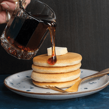 Golden maple syrup pouring onto stack of mini silver dollar pancakes from Nordic Ware pancake pan