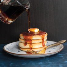Golden maple syrup pouring onto stack of mini silver dollar pancakes from Nordic Ware pancake pan