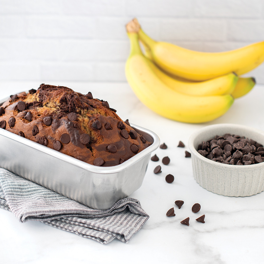 Dark chocolate banana bread baked in Nordic Ware natural aluminum 1-pound loaf pan with baking ingredients