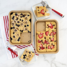 Two Nordic Ware aluminum nonstick eighth sheet pans with golden sheet pan pancakes topped with fresh berries