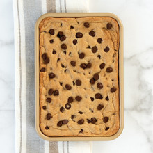 Nordic Ware aluminum eighth sheet baking pan with golden baked cookies, natural finish with raised edges