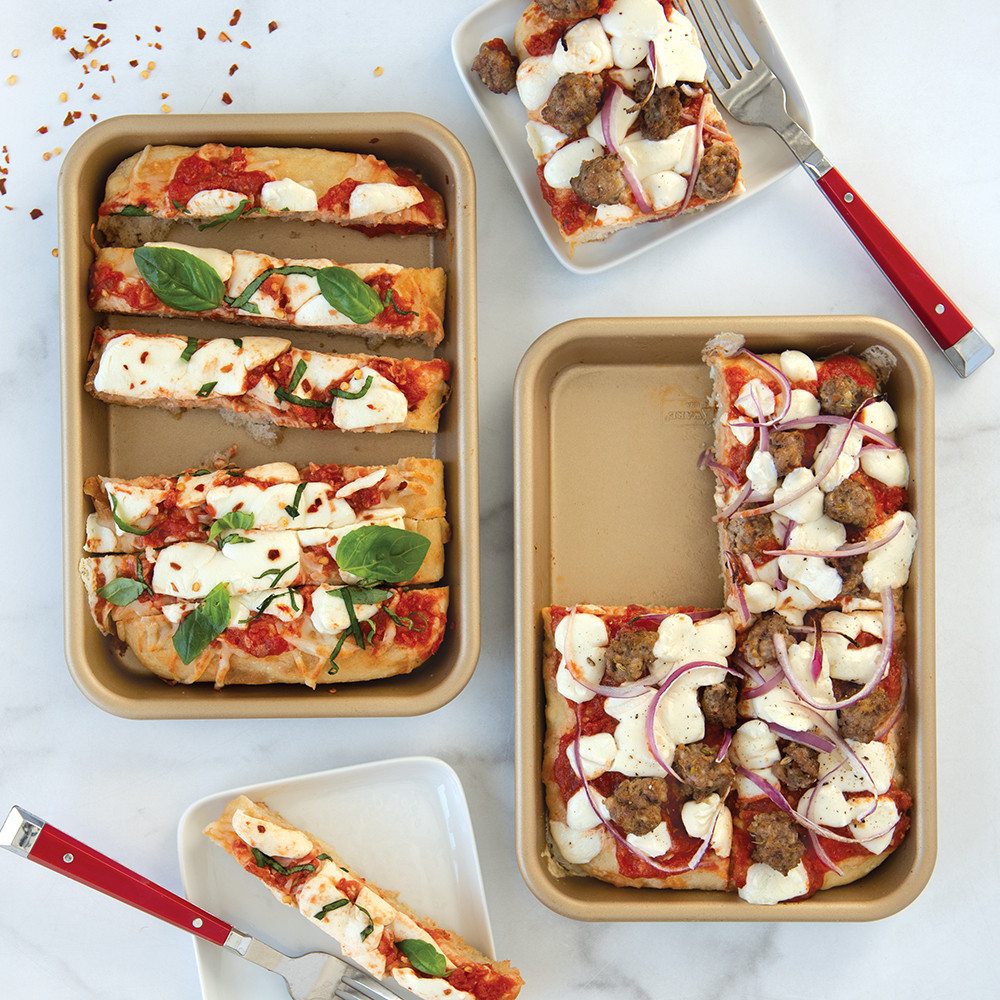 Two Nordic Ware aluminum eighth sheet pans with natural finish, one topped with baked mini pizzas with golden crust
