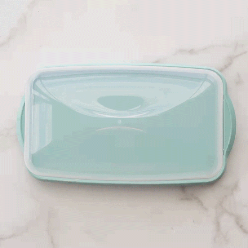 Golden braided loaf cake displayed on Nordic Ware aluminum loaf keeper with vented lid