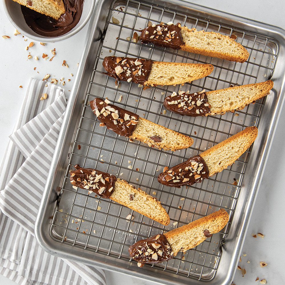 Chocolate-dipped biscotti arranged on Nordic Ware quarter sheet wire cooling grid, silver metal rack