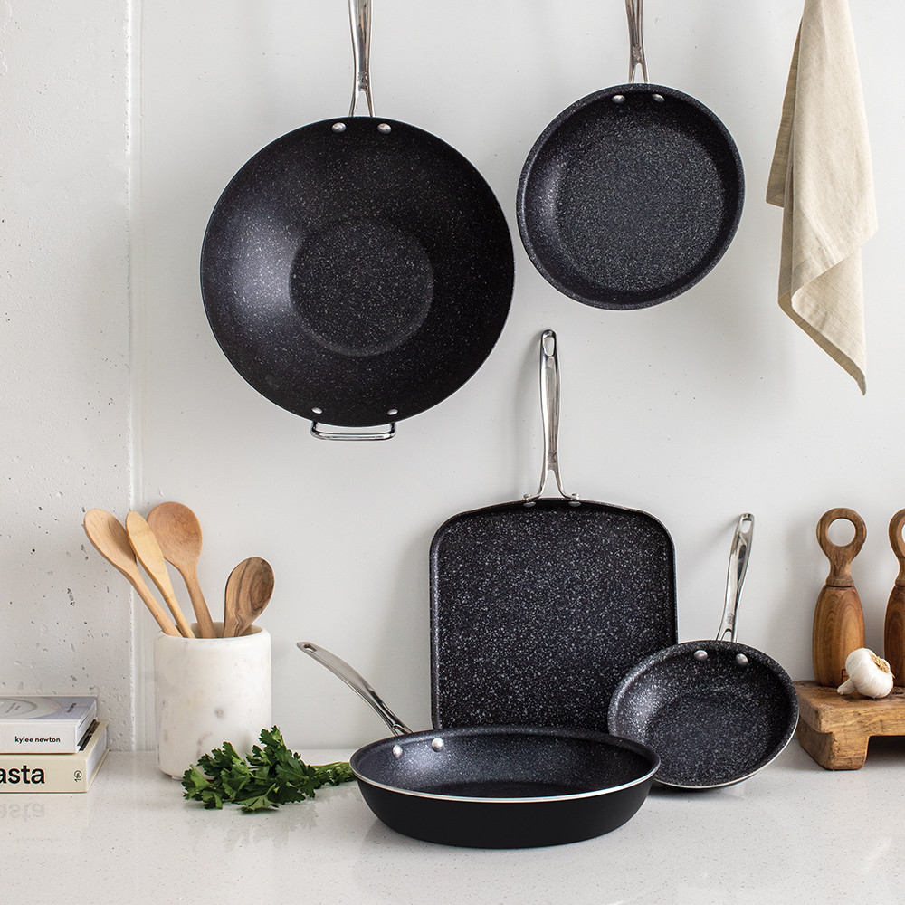 Nordic Ware Basalt ceramic cookware set with 5 dark gray pieces arranged on marble countertop in modern kitchen