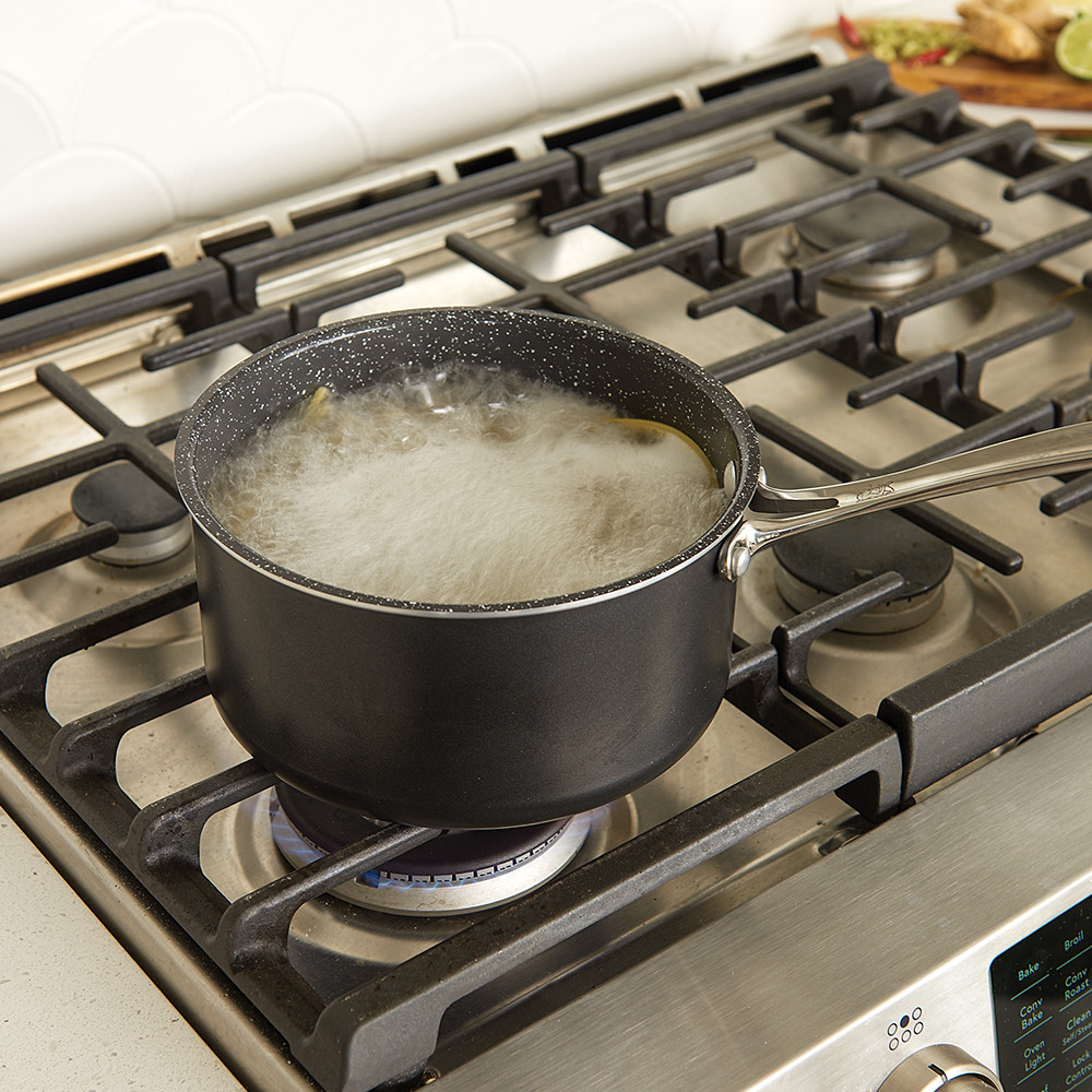 Nordic Ware Basalt dark gray 3-quart sauce pan on stovetop with boiling pasta water