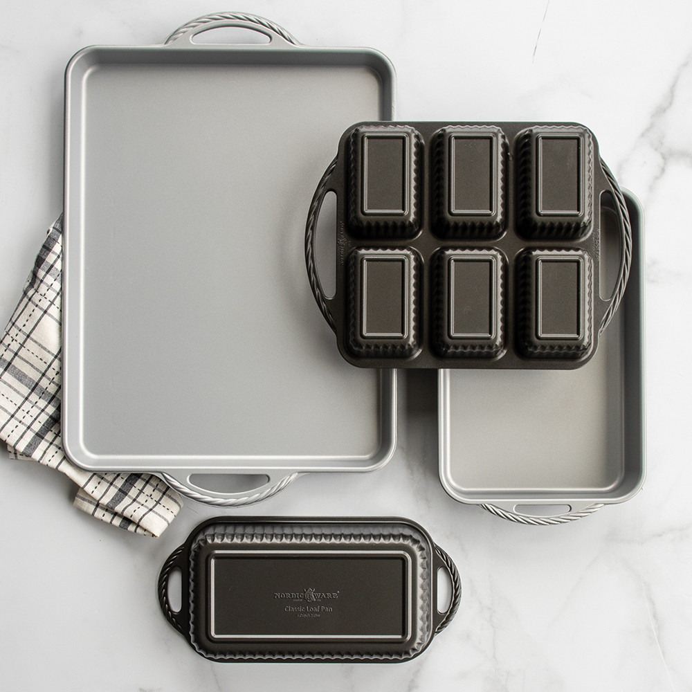 Nordic Ware ProCast nonstick baking pans in graphite gray with light interior coating on marble surface
