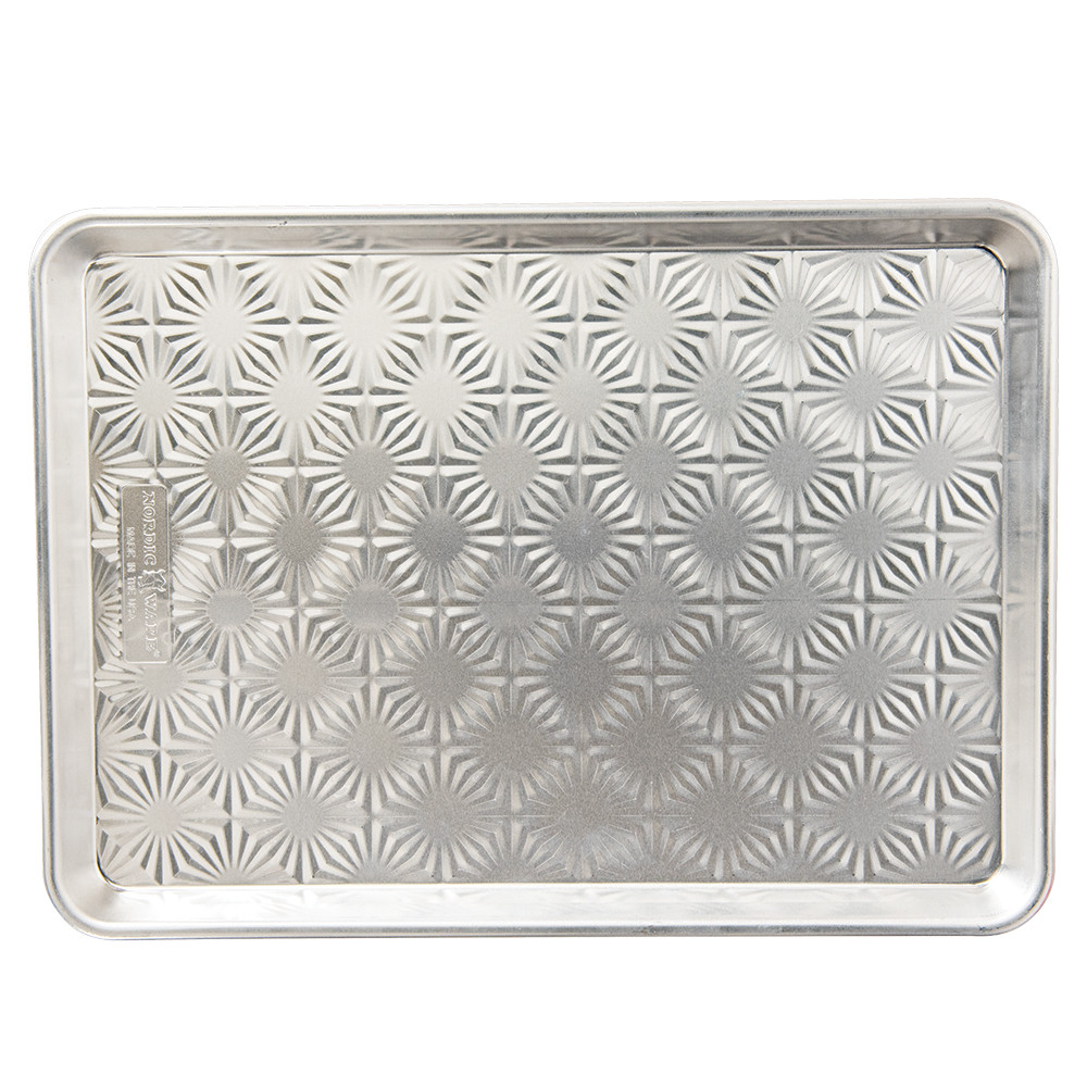 Nordic Ware aluminum half sheet pan with decorative starburst pattern embossed on bottom, natural silver finish