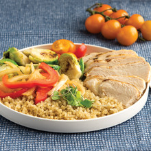 Nordic Ware white ceramic lunch plate with prepared meal on blue placemat, cherry tomatoes alongside