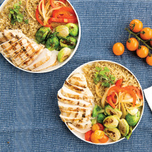 Nordic Ware white ceramic lunch plate with compartments holding colorful meal on blue placemat