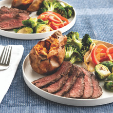 Two Nordic Ware aluminum meal plates with grilled steak and roasted vegetables, showing natural silver finish