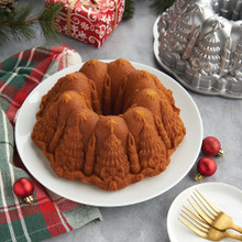 Golden bundt cake with decorative holiday pattern from Nordic Ware Very Merry Bundt pan, aluminum pan visible in background