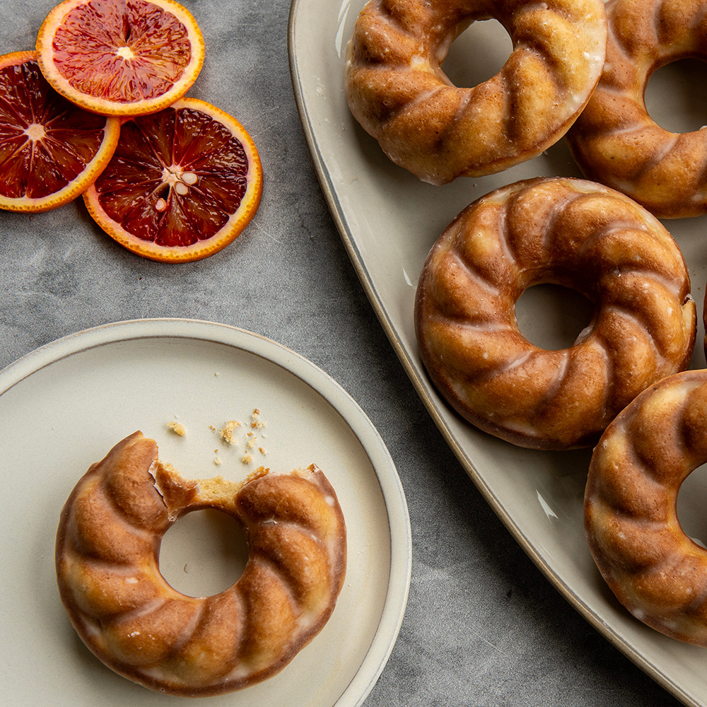 Golden twisted donuts baked in Nordic Ware French Twist aluminum donut pan, spiral ridged design visible