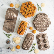 group shot of honey hive loaf pan, honey bee cookie stamps, beehive cakelet pan, honeycomb pull apart pan, beehive cake pan, and busy bee bitelet pan