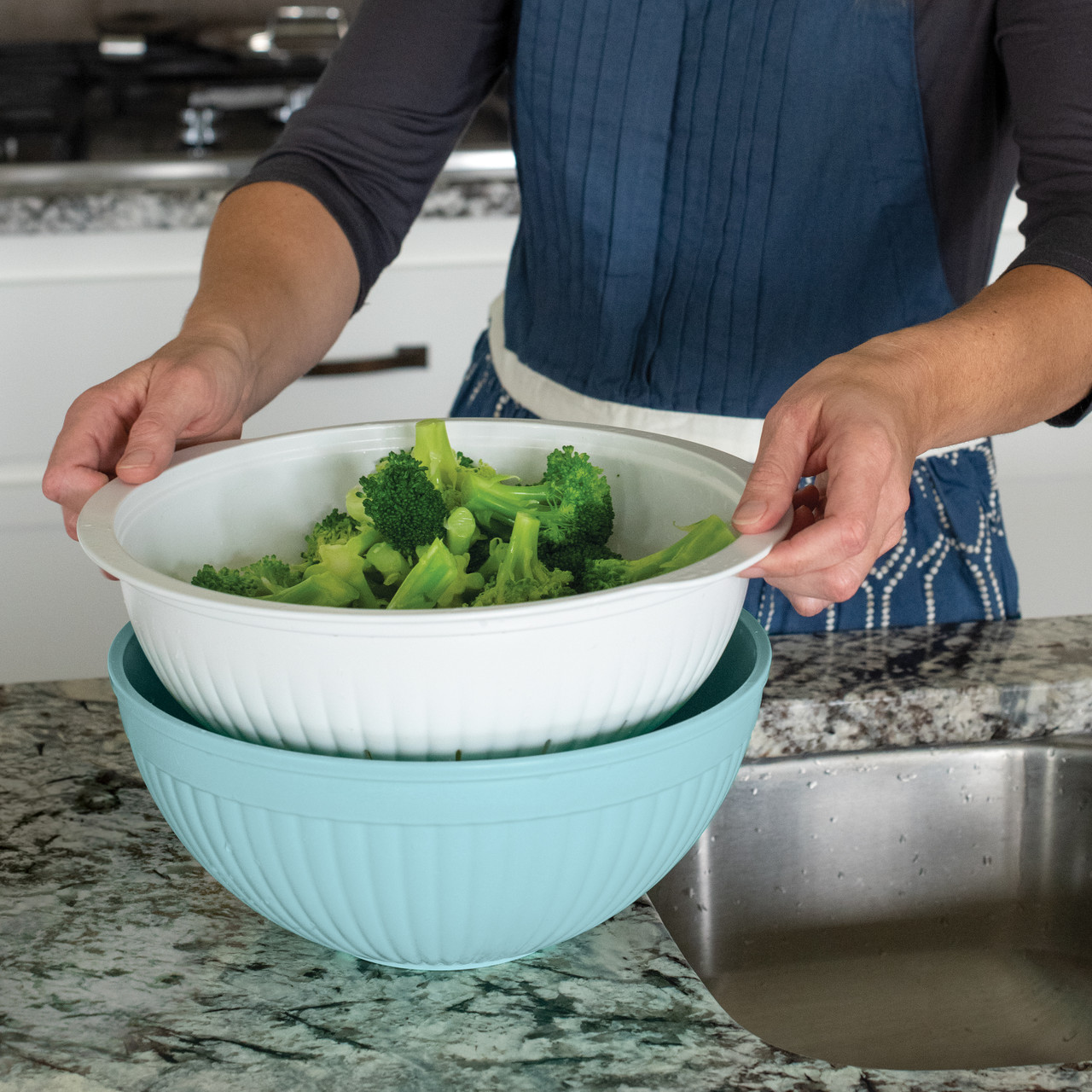 Sea glass green plastic colander nested in matching bowl with fresh green broccoli florets