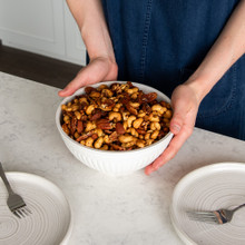 hands holding Nordic Ware 2 quart bowl filled with mixed nuts