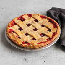 Cherry pie with golden lattice crust baked in Nordic Ware aluminum 9-inch pie pan with fluted edges