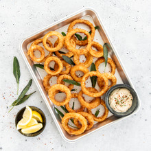 Nordic Ware aluminum quarter sheet baking pan with golden-brown crispy onion rings arranged on surface