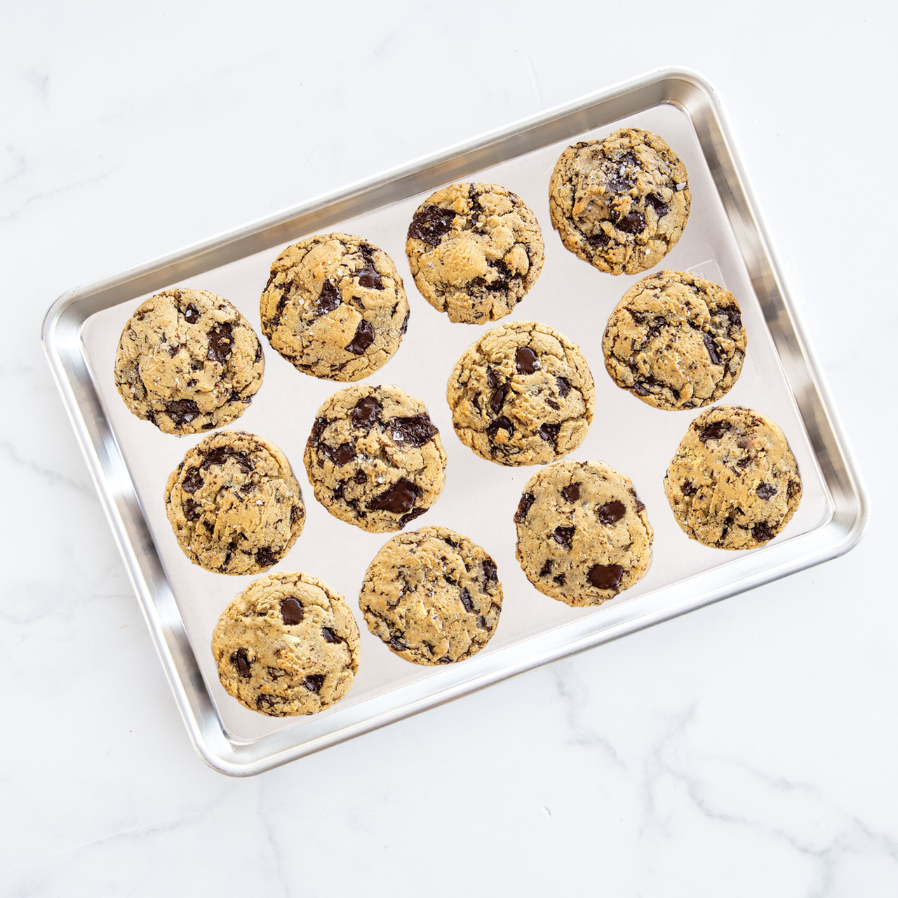 Nordic Ware aluminum half sheet baking pan with golden brown cookies, natural silver finish