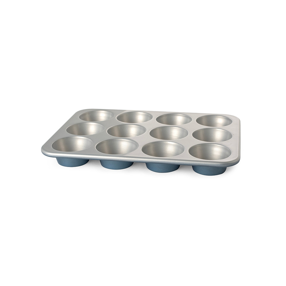 Nordic Ware Brilliant Muffin Pan with 12 cups, aluminum construction, interior angled view showing non-stick surface