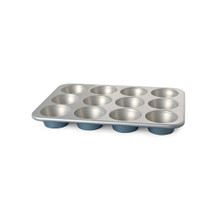 Nordic Ware Brilliant Muffin Pan with 12 cups, aluminum construction, interior angled view showing non-stick surface