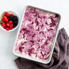 Nordic Ware aluminum 9x13 baking pan with baked rippled granola bars, bowl of fresh berries alongside