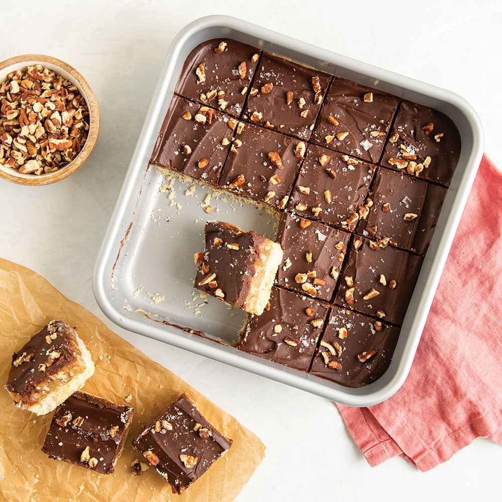 Cut turtle millionaire bars with chocolate and caramel layers in Nordic Ware nonstick square baking pan
