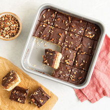 Cut turtle millionaire bars with chocolate and caramel layers in Nordic Ware nonstick square baking pan
