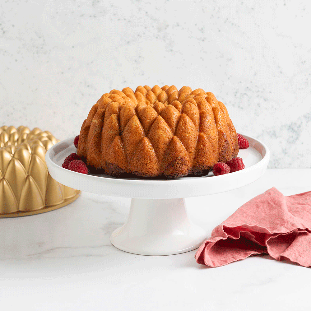Batter being poured into Nordic Ware Kaleidoscope Bundt pan showing intricate geometric pattern design