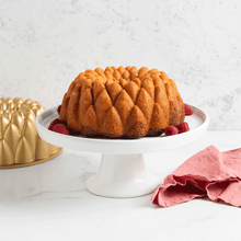 Batter being poured into Nordic Ware Kaleidoscope Bundt pan showing intricate geometric pattern design