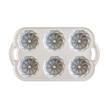 Nordic Ware Pirouette Bundtlette pan interior showing six fluted mini bundt cavities, cast aluminum finish
