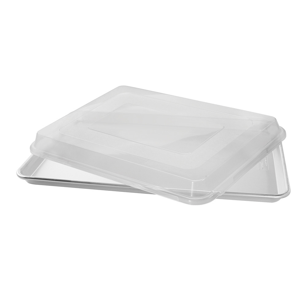 Nordic Ware aluminum big sheet pan with clear plastic lid partially removed, natural silver finish