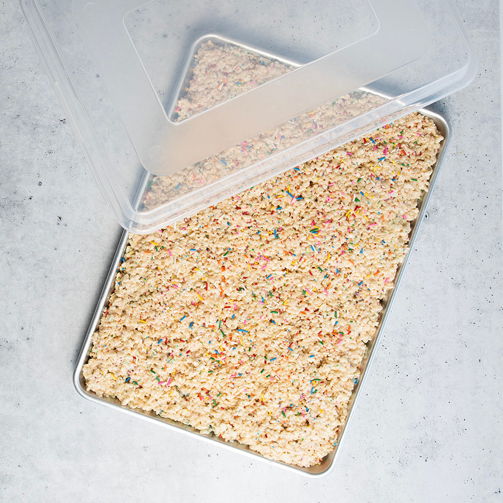 Nordic Ware aluminum sheet pan with lid containing golden rice crispy treats, overhead view