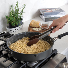 Nordic Ware Verde 12-inch ceramic nonstick skillet with lid cooking pasta and vegetables on stovetop