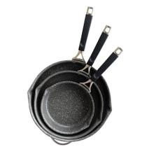 Three Nordic Ware Verde ceramic nonstick skillets in green finish, nested together with glass lid visible