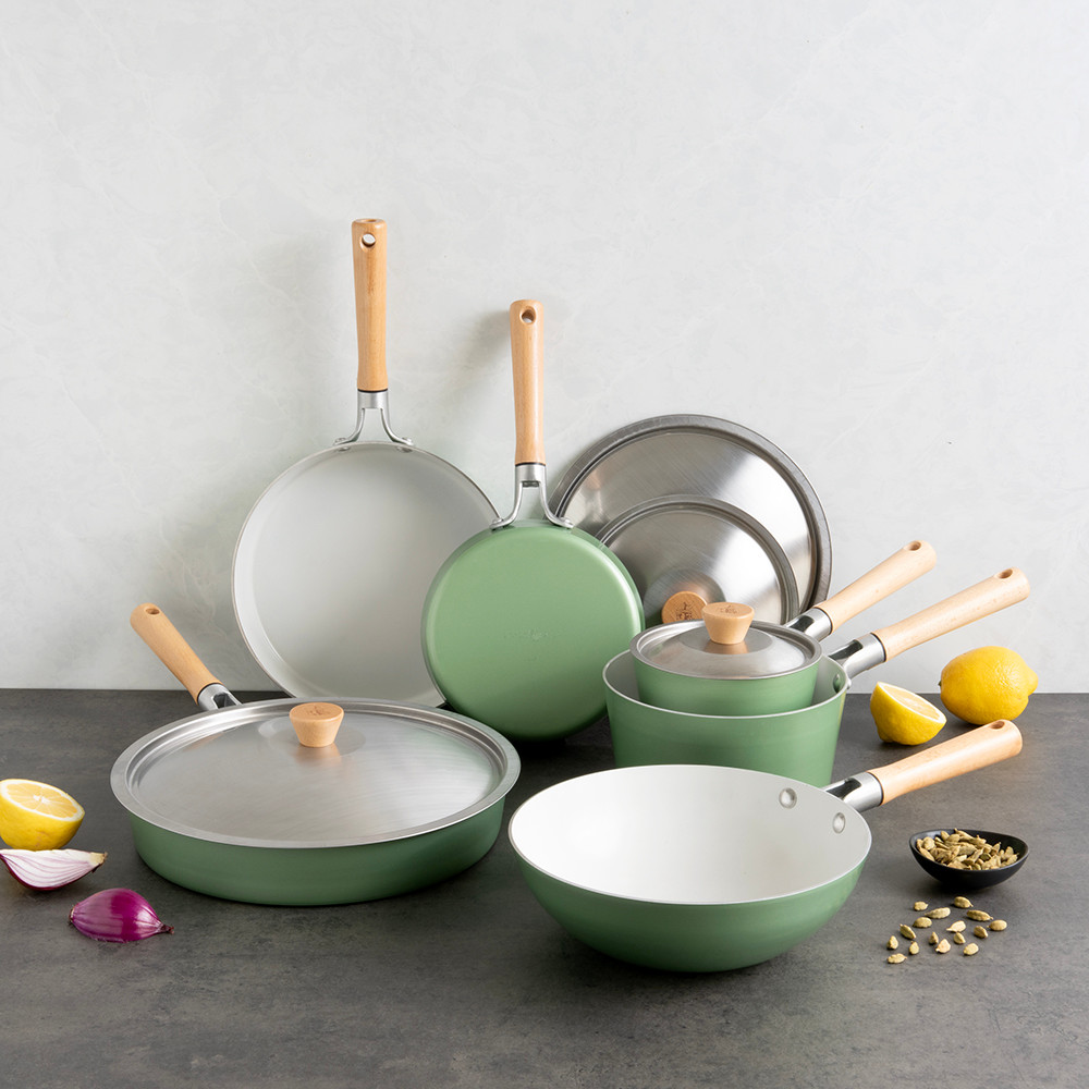 Nordic Ware Cardamom 10-piece nonstick cookware set with lids in warm copper tone, displayed with fresh ingredients