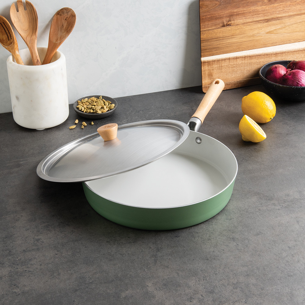 Nordic Ware Cardamom 12-inch nonstick frying pan with glass lid, speckled gray finish, styled with cooking ingredients