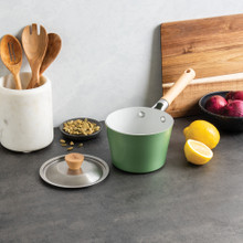 Nordic Ware Cardamom 1.5-quart aluminum saucepan with lid, cream exterior, styled with cooking ingredients