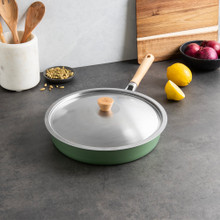 Nordic Ware 12-inch stainless steel sauté pan with matching lid on kitchen counter beside fresh ingredients