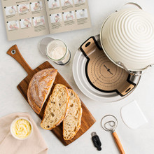 Nordic Ware 9-piece sourdough bread baking kit with sliced artisan bread, aluminum loaf pan, and baking accessories on white surface
