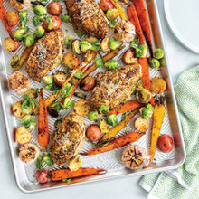 Roasted chicken thighs and colorful vegetables on Nordic Ware Prism aluminum sheet pan, golden brown and caramelized