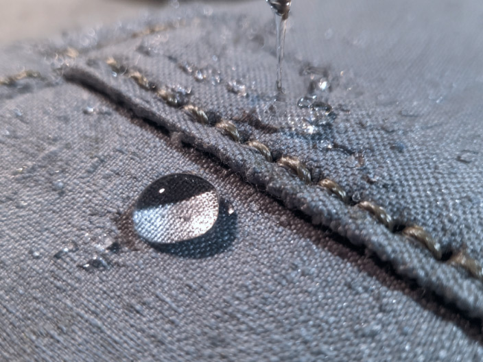 fabric close up showing woven texture and pooled water droplets
