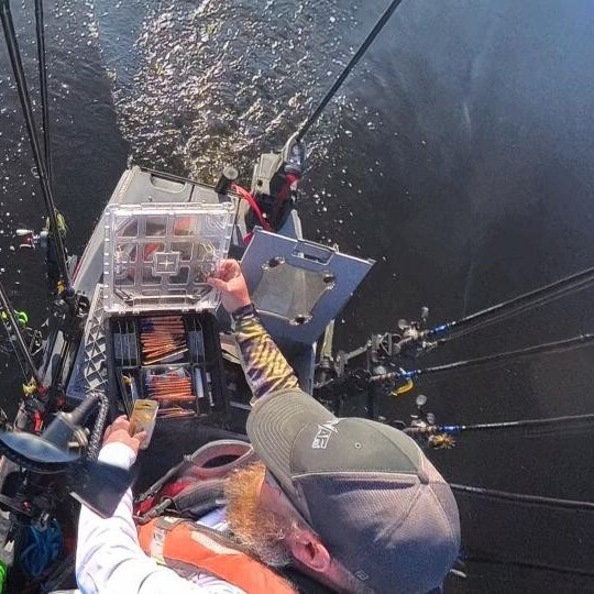 Overhead view of an angler accessing organized tackle from a customized fishing kayak.