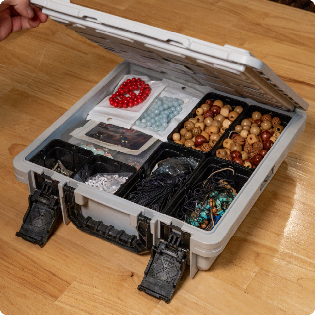 Open gray BaseBox with divided compartments organizing beads, jewelry-making supplies, cords, and small craft materials.