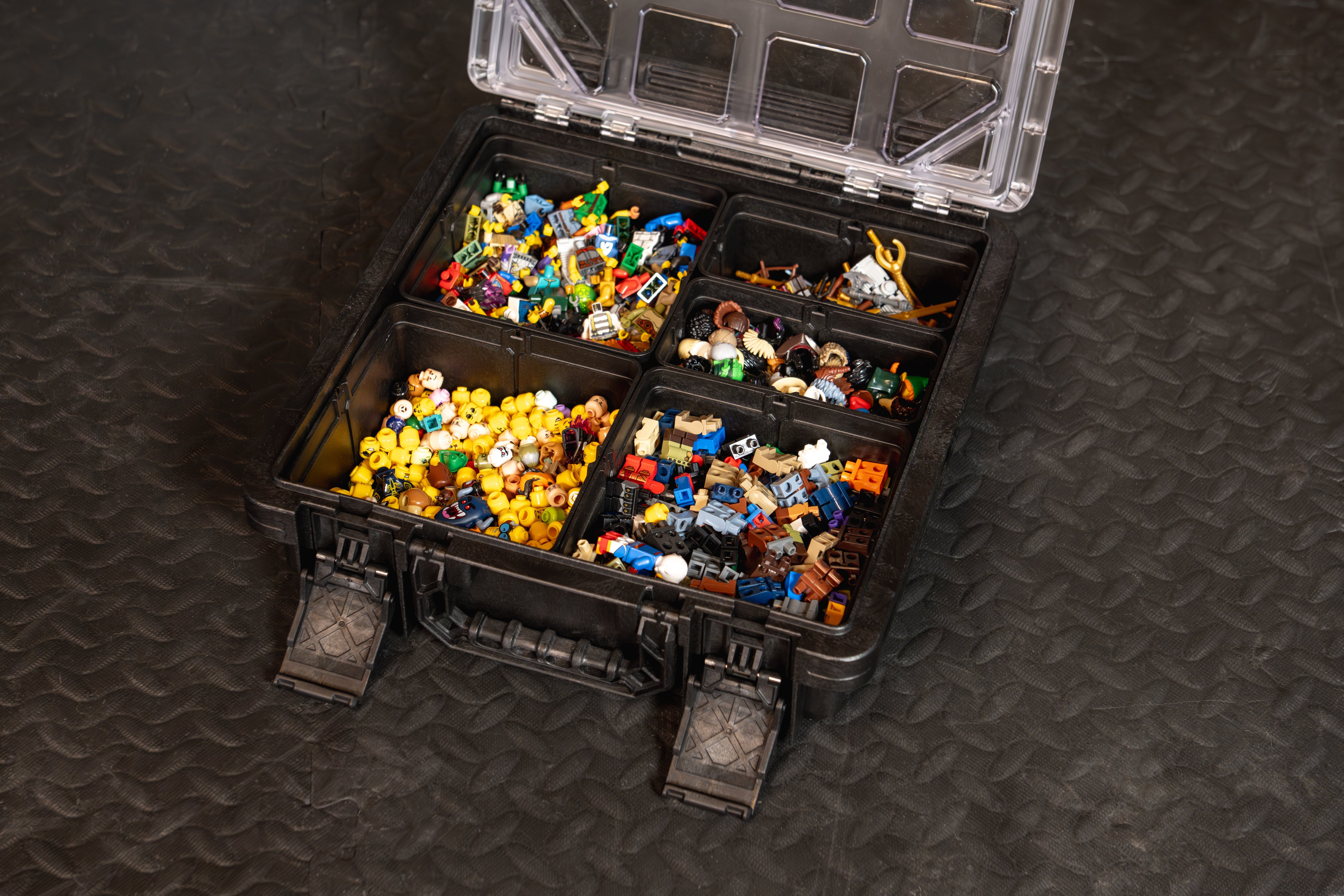 BaseBox™ organizer storing sorted LEGO® bricks, minifigure parts, and building accessories in removable bins