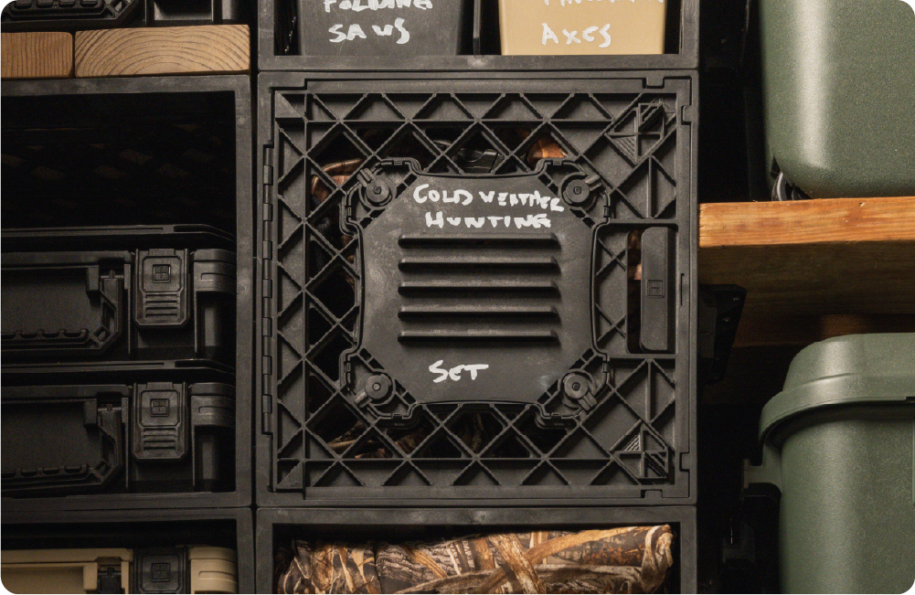 Black UbeCube crate storage setup with a Locker Panel labeled Cold weather hunting set and stacked organized hunting gear on a shelf.