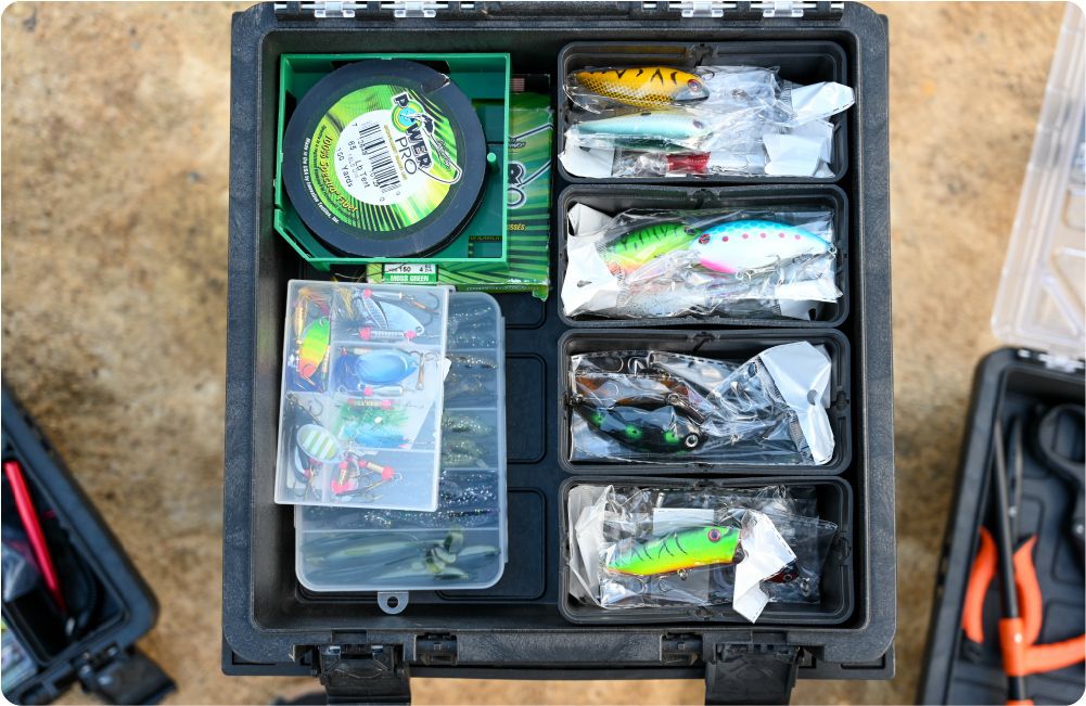 Open BaseBox tackle box organized with fishing lures, line, and small tackle trays.