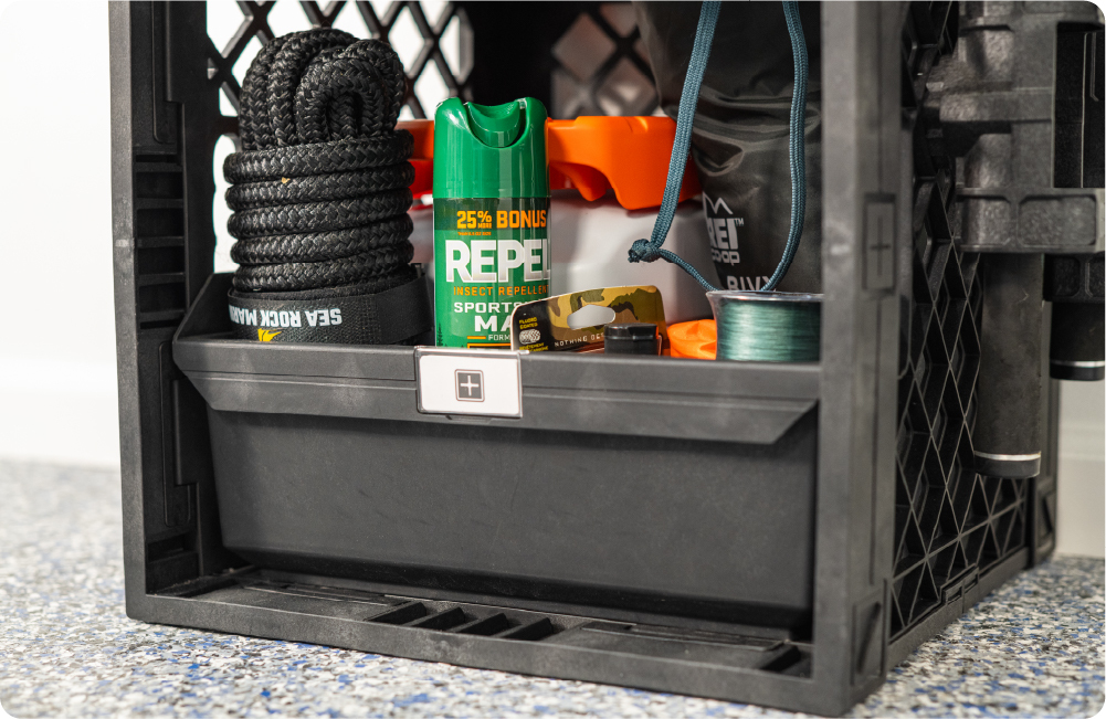 Large Grab Bin inside a black UbeCube crate storing rope, insect repellent, fishing line, and outdoor gear.